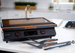 Blackstone 22inch E Series Electric Griddle on white bench with accessories