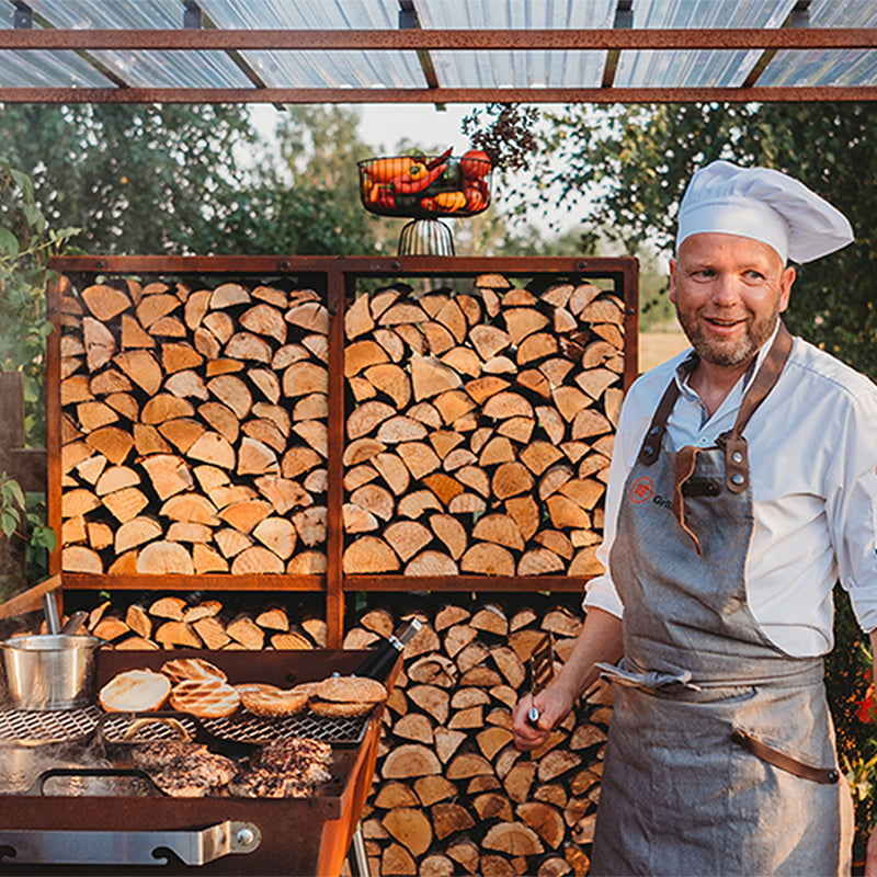 GrillSymbol Charcoal Grill Naked Chef XXL grilling meat patties by firewood racks