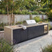 Maze Monarch outdoor kitchen with grill, sink, and refrigerator in a garden setting