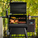 Traeger Pro575 Black international with hood open, front view with grills full.